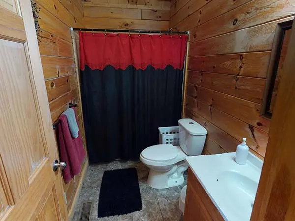 Bathroom with black and red shower curtain
