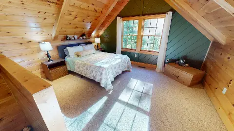 Loft bedroom with queen bed and green accent wall