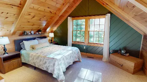Loft bedroom with windows looking into the trees