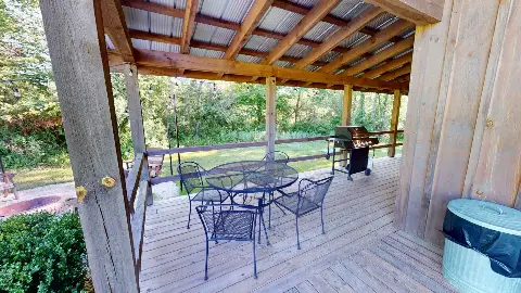 Covered deck with patio table, chairs and gas grill