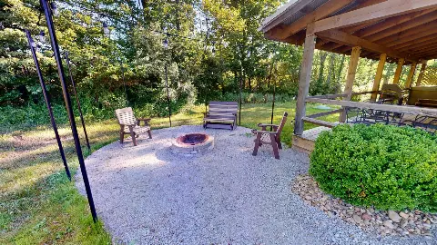 Gravel fire pit area with chairs and string lights