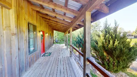 Long covered porch leading to the red front door