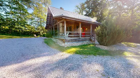 Twin Pine Cottage exterior with metal roof and gravel drive