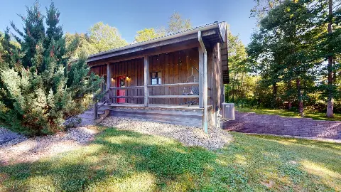 Side view of the cottage porch among evergreens