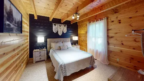 Main floor bedroom with navy accent wall and lamps
