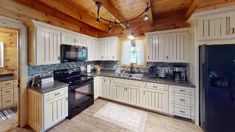 Kitchen with white cabinets, electric range and coffee station