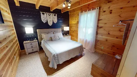 Main floor bedroom with queen bed and navy accent wall